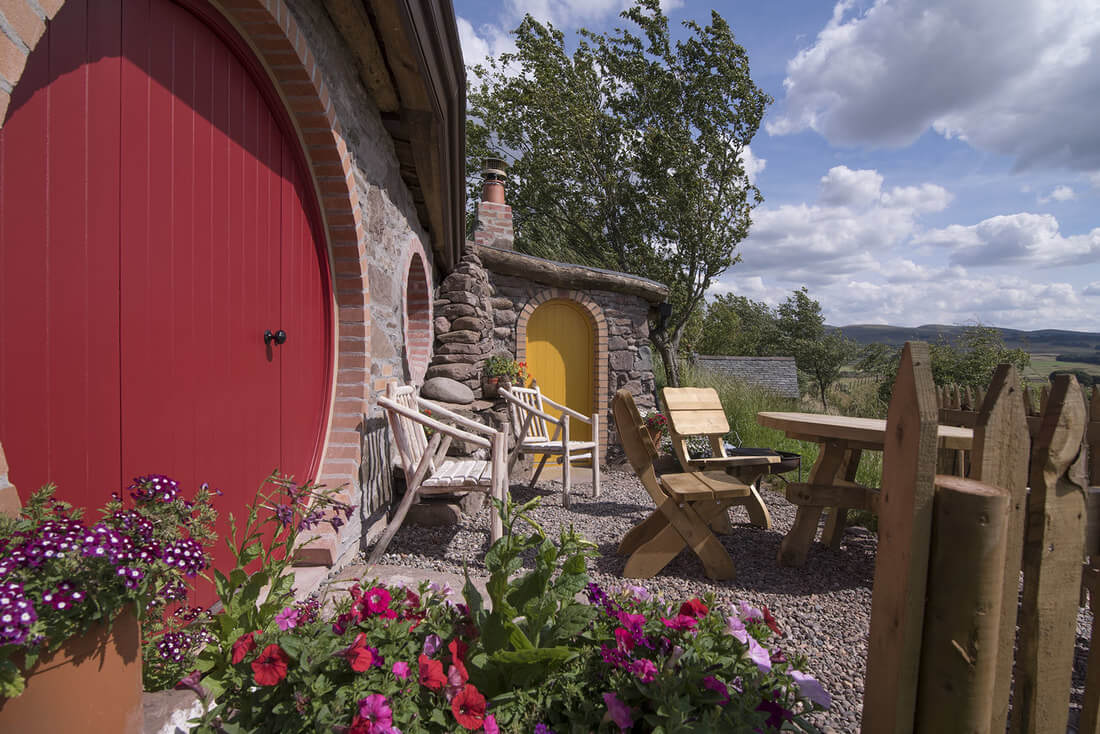 Unique hobbit hole glamping cottage with red door