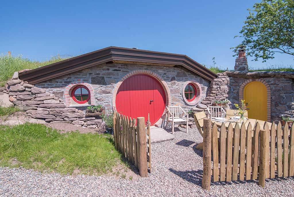 Unique hobbit hole glamping cottage with red door