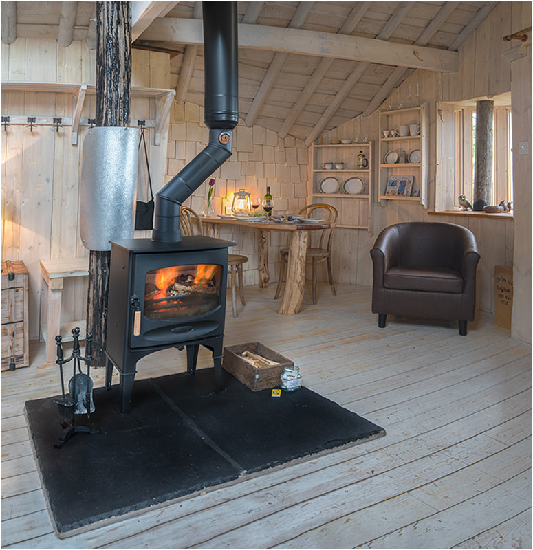 Wood stove in romantic getaway glamping treehouse
